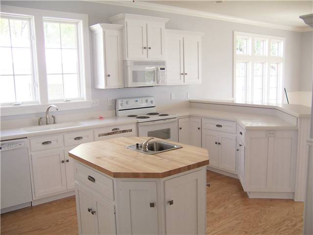 Painted cabinets - Flat panel doors, drawer fronts, and side panels - Solid surface countertops on the perimeter and a butcher block countertop on the island
